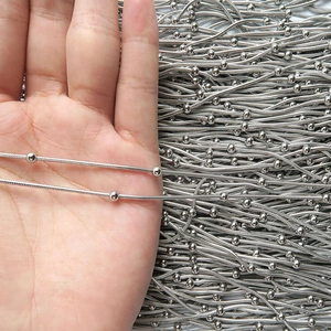 Detail of silver stainless steel snake bone chain with small metal beads held in hand