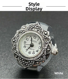 Macro shot of silver ring watch featuring a white dial with numeric markers and floral relief