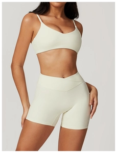 Detail of cream white yoga set featuring V-neck sports bra and V-cross high waist shorts