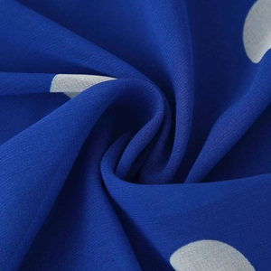 Gros plan sur le tissu à pois bleus d'une robe dos nu vintage au fini léger
