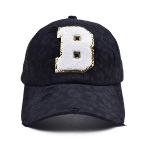 Detail of distressed leopard print baseball cap with fuzzy B patch and gold sequins