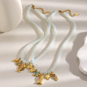 Détail de colliers perlés plaqués or 18 carats avec pendentifs coquillage et poulpe