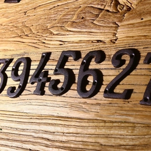 Numeri civici rustici in ghisa nera 9 4 5 6 2 montati su una tavola di legno grezzo