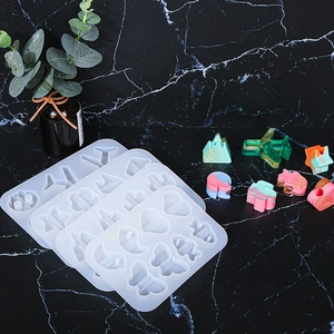 Detail of DIY silicone molds for resin featuring butterfly and star shapes on marble