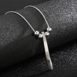 Detailed close-up of a silver stainless steel spiral bar pendant on a snake bone chain