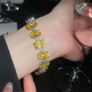 Detailed view of silver bracelet with oval yellow zircons worn elegantly on a wrist