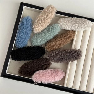 Plush lamb wool hair clips set in 9 candy colors on a cream jewelry display tray
