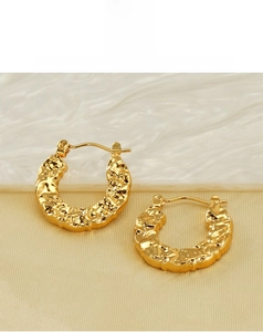 Detail of 18K gold plated hoop earrings with unique hammered lava texture design