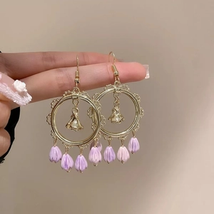 Floral gold hoop earrings with light purple bud pendants and elegant tassel charms