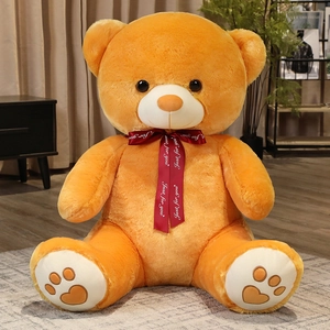Close-up of giant orange teddy bear with red Just for you ribbon and heart paw embroidery