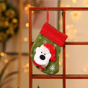 Green Christmas stocking with polar bear plush toy, white snowflakes, and red cuff decor