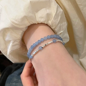 Gros plan d'un bracelet à double couche avec perles d'aigue-marine et détails argentés