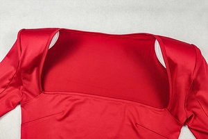 Detail of red square neck long sleeve dress featuring padded shoulders and silky fabric