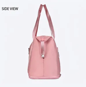 Side view of pink waterproof travel bag showing reinforced handles and metal zipper detail
