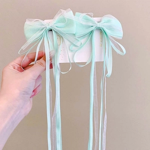 Detail of mint green double-layer organza bow hair clips with long satin ribbons