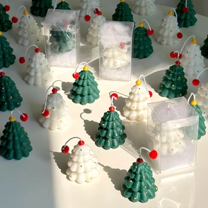 Macro detail of mini Christmas tree candles in green and white festive packaging