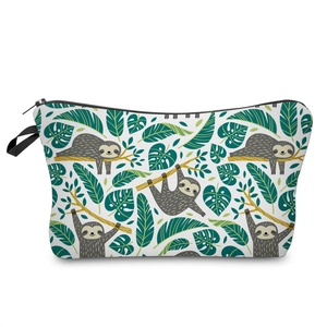 Close-up detail of a white travel cosmetic bag featuring cute sloth and tropical leaf prints