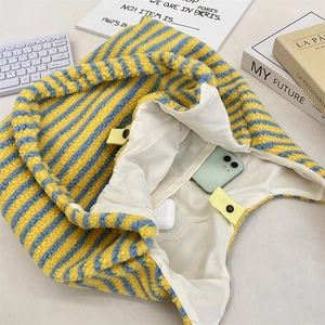 Detail der flauschig gestreiften Tasche zeigt großes Fassungsvermögen mit Handy und Etui