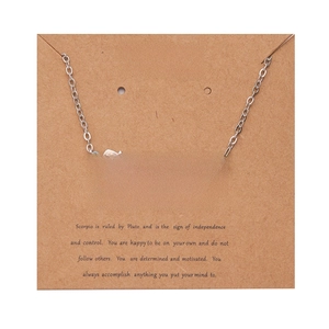 Macro view of Scorpio zodiac necklace pendant in Old English font on brown display card