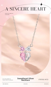 Close-up of 925 sterling silver heart pendant with pink cubic zirconia and bow detail