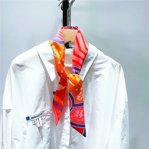 Detail of multi-color geometric twill silk scarf tied on a white shirt collar