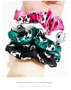 Elastic satin soccer scrunchies in pink, white, black and green worn as bracelets