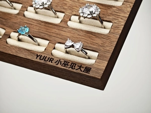 Macro view of assorted silver jewelry rings with zircons on a walnut wooden display tray
