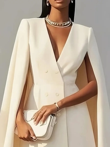 Detail of white double-breasted cape dress with V-neck and luxury gold jewelry
