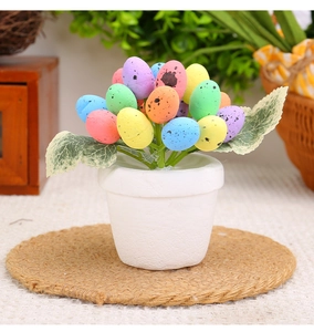Macro detail of colorful spotted Easter eggs in a white pot with green leaves