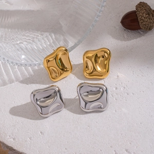 Lava design square stud earrings in 18K gold and silver finish on a textured stone surface