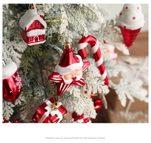 Macro detail of red and white Christmas tree ornaments on snow-covered pine branches
