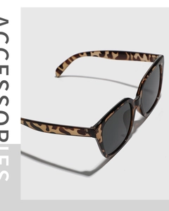 Detail of square oversized tortoise shell sunglasses with wide temples and smoke lenses