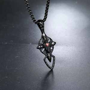 Macro shot of gothic cross wing pendant with red crystal inlay on black box chain