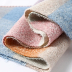 Macro shot of soft faux cashmere scarf showing multi-color plaid texture and plush fibers