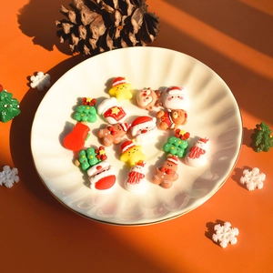 Christmas resin charms featuring Santa, reindeer, and trees in a white decorative bowl