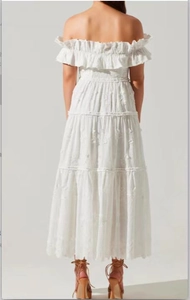 Detail of white off-shoulder maxi dress with tiered ruffles and intricate lace embroidery