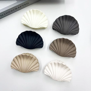 Macro view of textured fan-shaped hair clips in various marble patterns and neutral colors