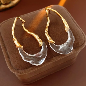 Detailed view of irregular 18k gold plated teardrop earrings on a velvet jewelry box