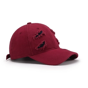 Vintage distressed burgundy cotton baseball cap with ripped details shown in 45-degree view