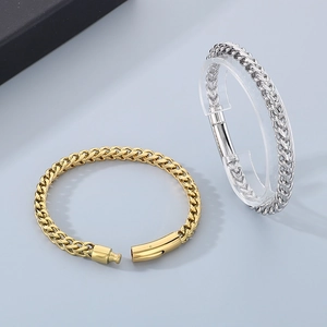 Macro detail of gold and silver stainless steel wheat chain bracelets with secure clasps