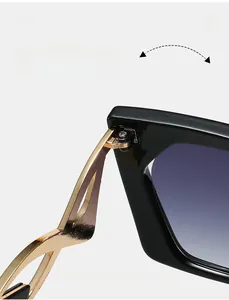 Detailed close-up of durable metal hinges on oversized black and gold frame sunglasses