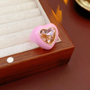 Detail of pink enamel heart ring with a champagne gem set in a gold frame
