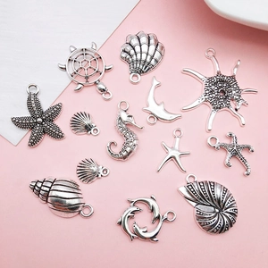 Set of 12 silver antique-style ocean charms featuring sea turtles, starfish, and shells