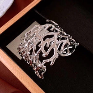 Macro view of silver organic coral branch texture on a polished wide open cuff bracelet