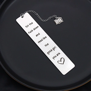 Stainless steel bookmark with book charm and engraved quote on a black background