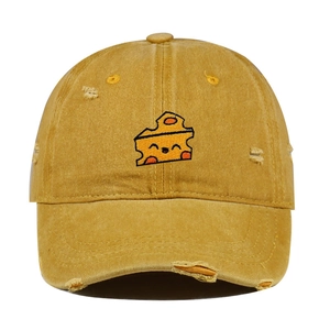 Close-up of ginger yellow distressed baseball cap with embroidered cheese pattern