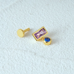 Macro shot of 16G gold cartilage stud with rectangular purple stone and blue round opal