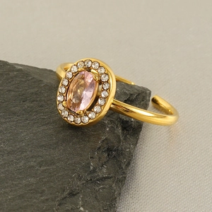 Detail of a gold adjustable ring featuring a pink oval gem surrounded by white crystals