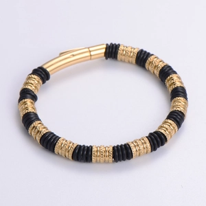 Detail of gold and black layered stainless steel bracelet with magnetic cylinder clasp
