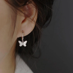 Boucles d'oreilles papillon en acier inoxydable plaqué or 18K portées par un mannequin